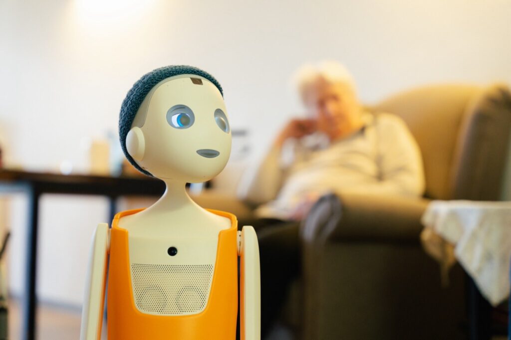 Pflege-Roboter im Senioren- und Pflegezentrum Lichtenberg mit älterer Person im Hintergrund.